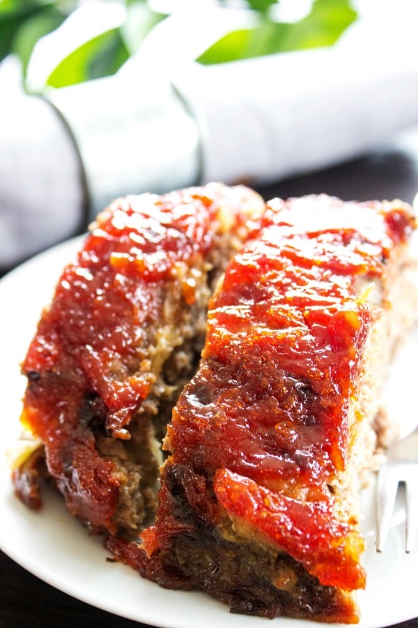 BROWN SUGAR MEATLOAF - Covered with a sweet brown sugar glaze this meatloaf full of flavor, it's the best meatloaf you will ever have. Grab a fork & dig in. two slices of meatloaf on a plate.