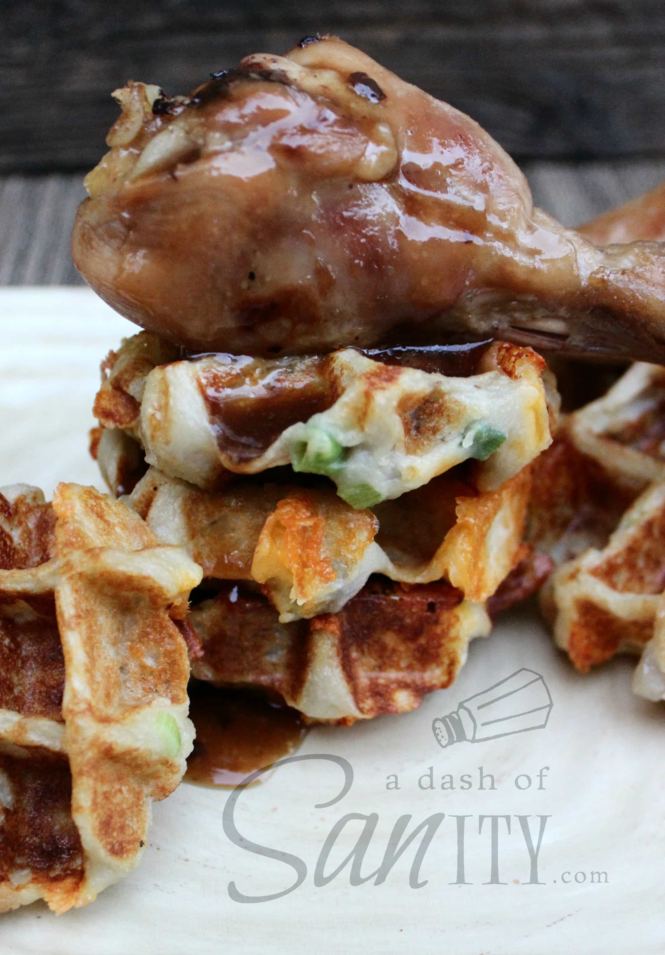 These delicious Maple Baked Chicken & Potato Waffles are a healthy and savory twist on your classic chicken and waffles recipe. Maple Baked Chicken & Potato Waffles, small waffles on a plate with a maple chicken drumstick on top