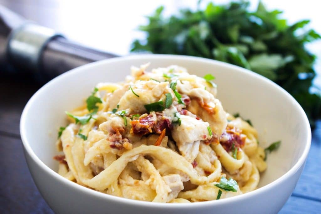 Chicken Fettuccine Bake – Filled to the brim with Alfredo sauce, tossed with chicken, bacon & sun-dried tomatoes, ready in just 45 minutes. the finished dish in a bowl