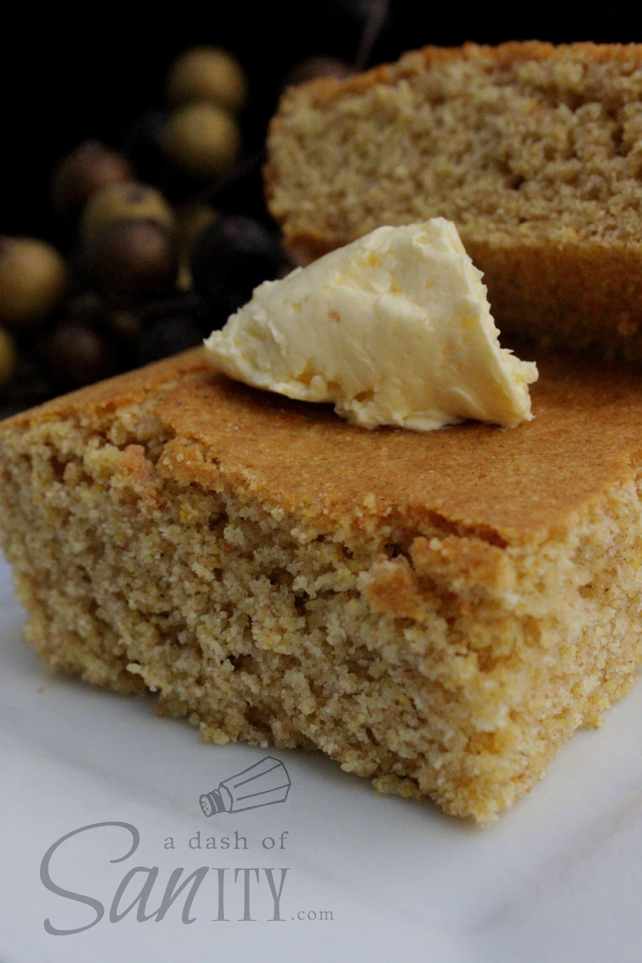 Whole Wheat Cornbread slices with a pat of butter served on a plate