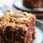 piece of chocolate almond coffee cake on black plate with fork