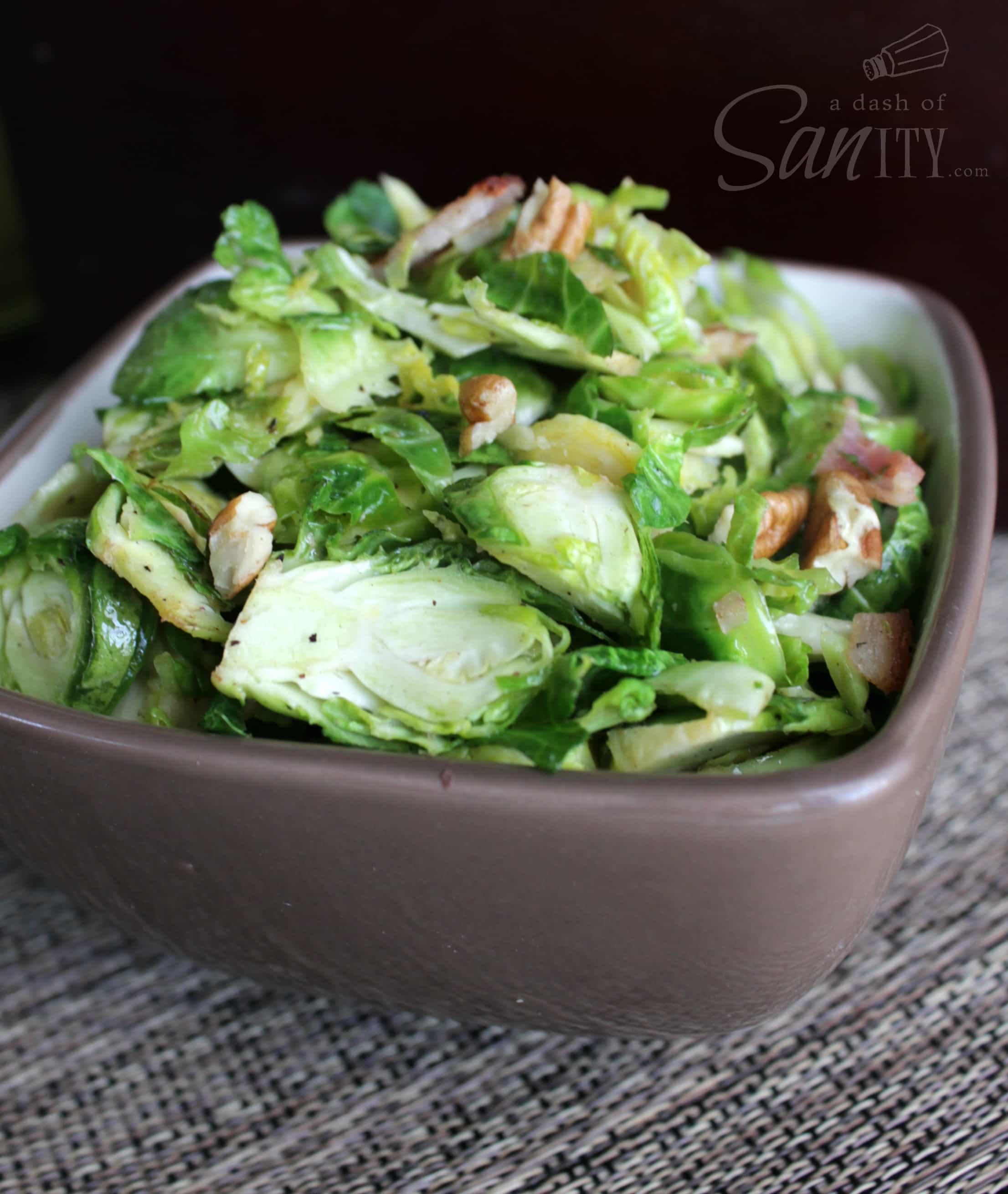 These Bacon and Walnut Brussel Sprouts are a delicious glazed side dish that pairs perfectly with any of your favorite meals. Bacon and Walnut Brussel Sprouts salad served in a bowl