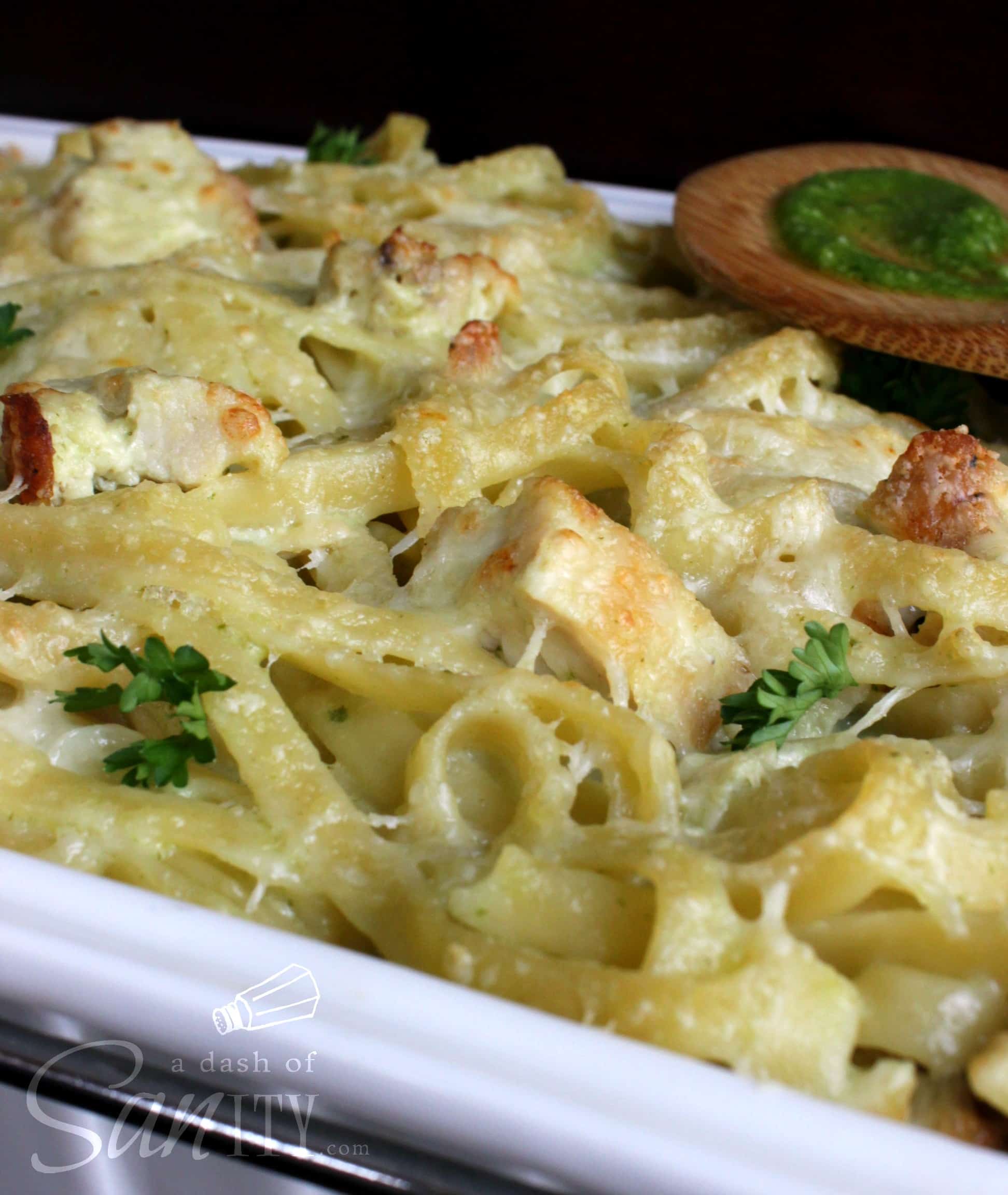This Creamy Pesto Alfredo Chicken Fettuccine Bake is a delicious cheesy dish that combines two favorite pasta sauces making one perfect meal. Creamy Pesto Alfredo Chicken Fettuccine Bake up close with a wooden spoon