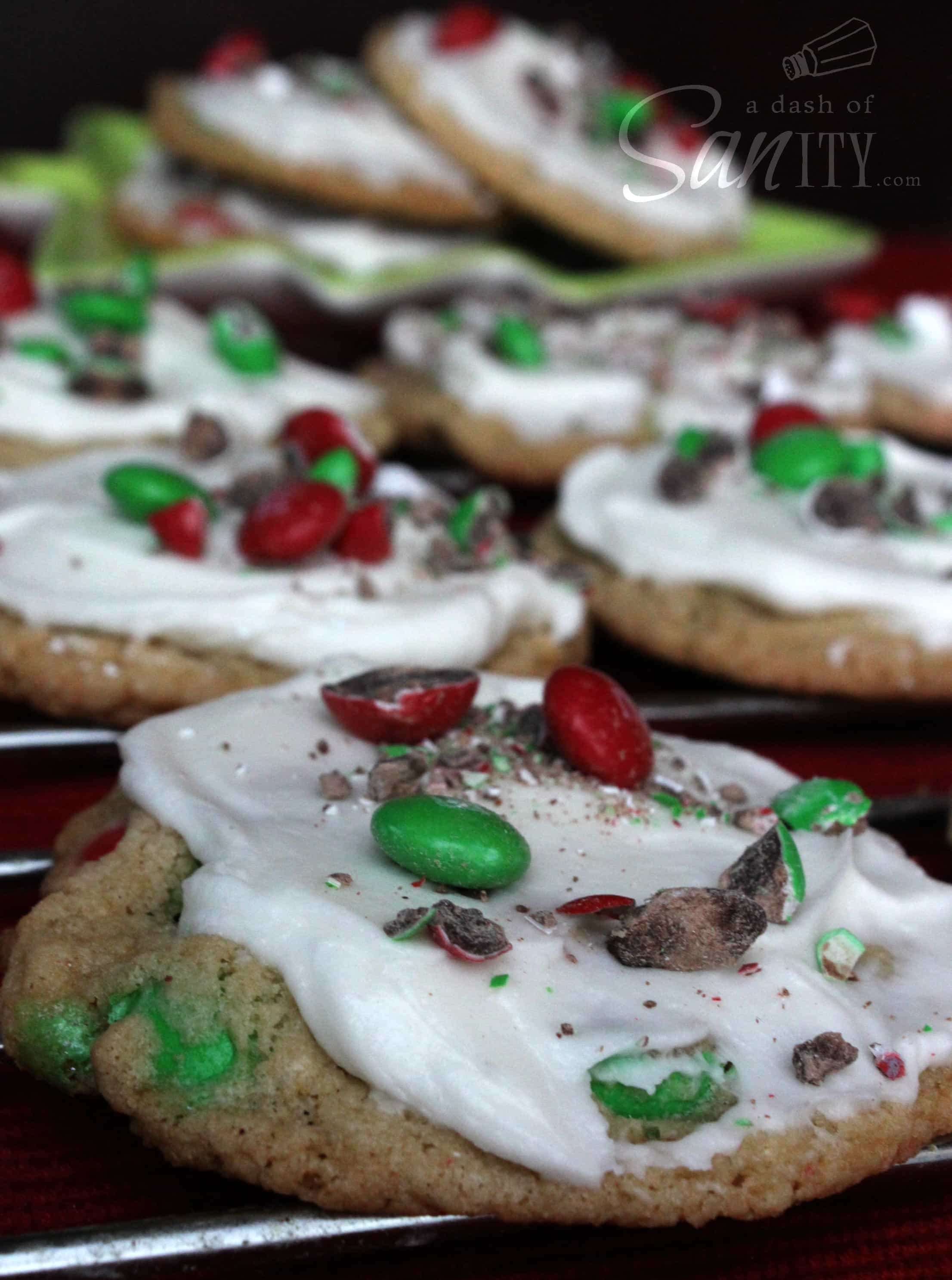 These Frosted Mint M&M Cookies are amazing. They take the amazing taste of M&Ms and combine it with mint to make the ultimate cookie. Frosted Mint M&M Cookies on a metal cooling rack
