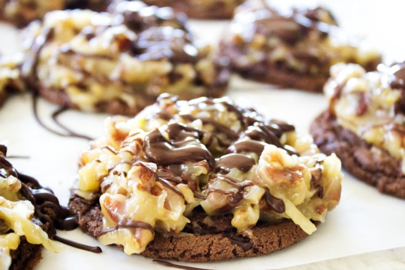 German Chocolate Cake Cookies - Soft, chewy chocolate cookies with a rich caramel, coconut, pecan frosting - these won't last long on the cookie plate. close up photo of german chocolate cake cookie with coconut pecan frosting and chocolate drizzle