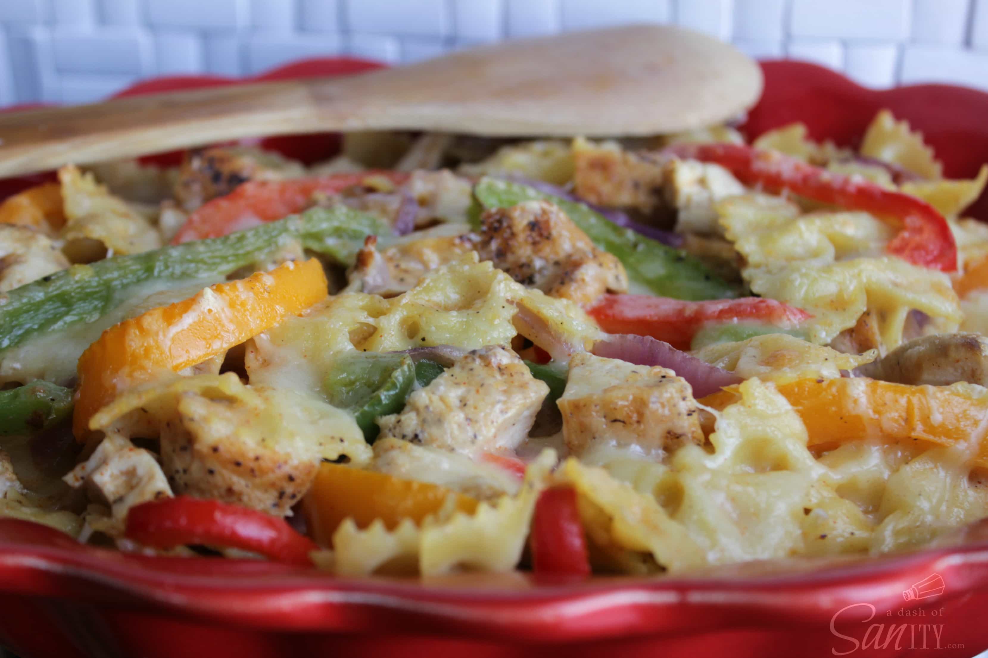 Cajun Chicken Pasta Bake in a red bowl with a wooden spoon