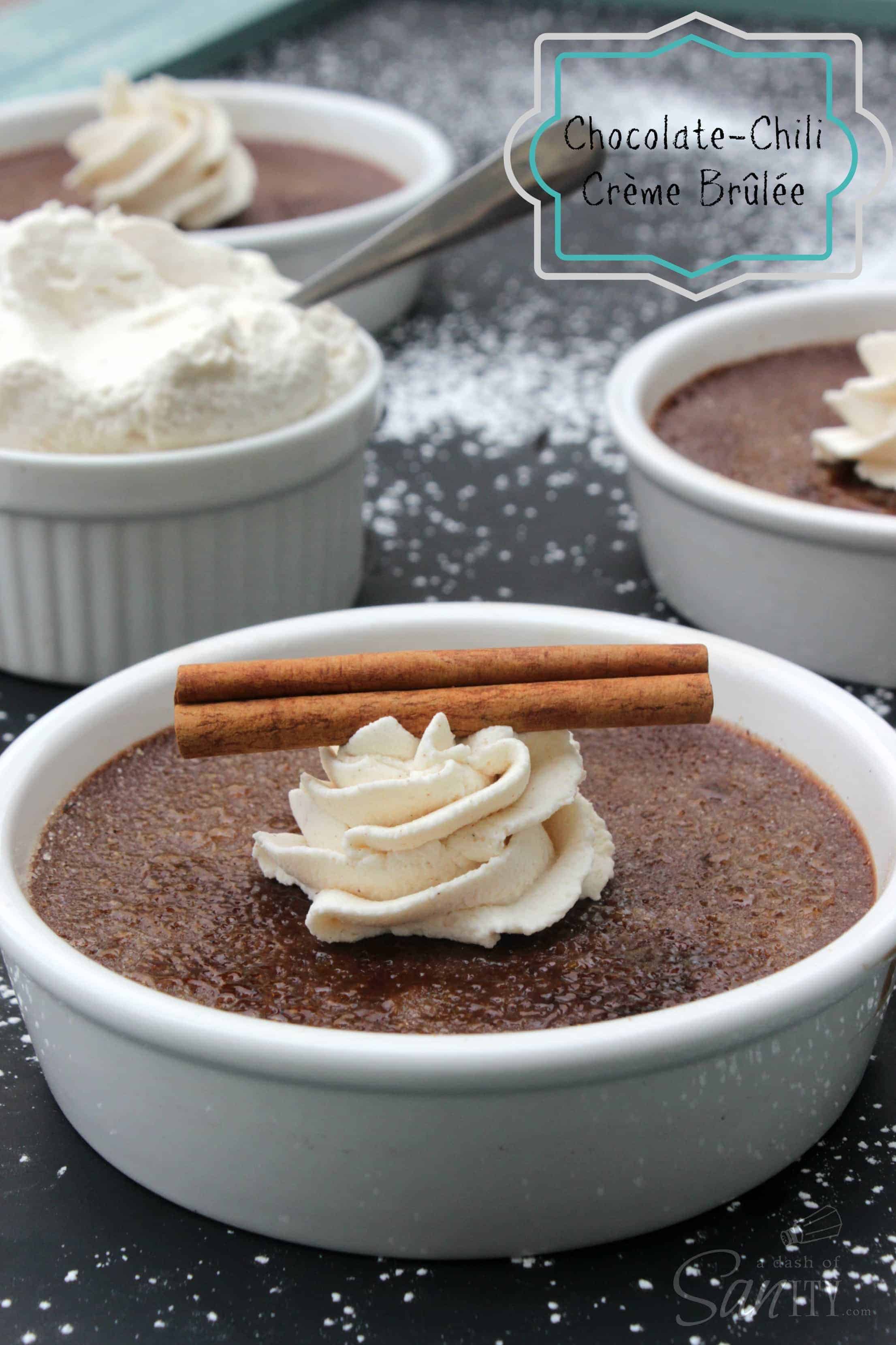 Chocolate-Ancho Chili Creme Brulee in 3 brulee dishes, topped with whipped cream and a cinnamon stick. bowl of whipped cream on counter