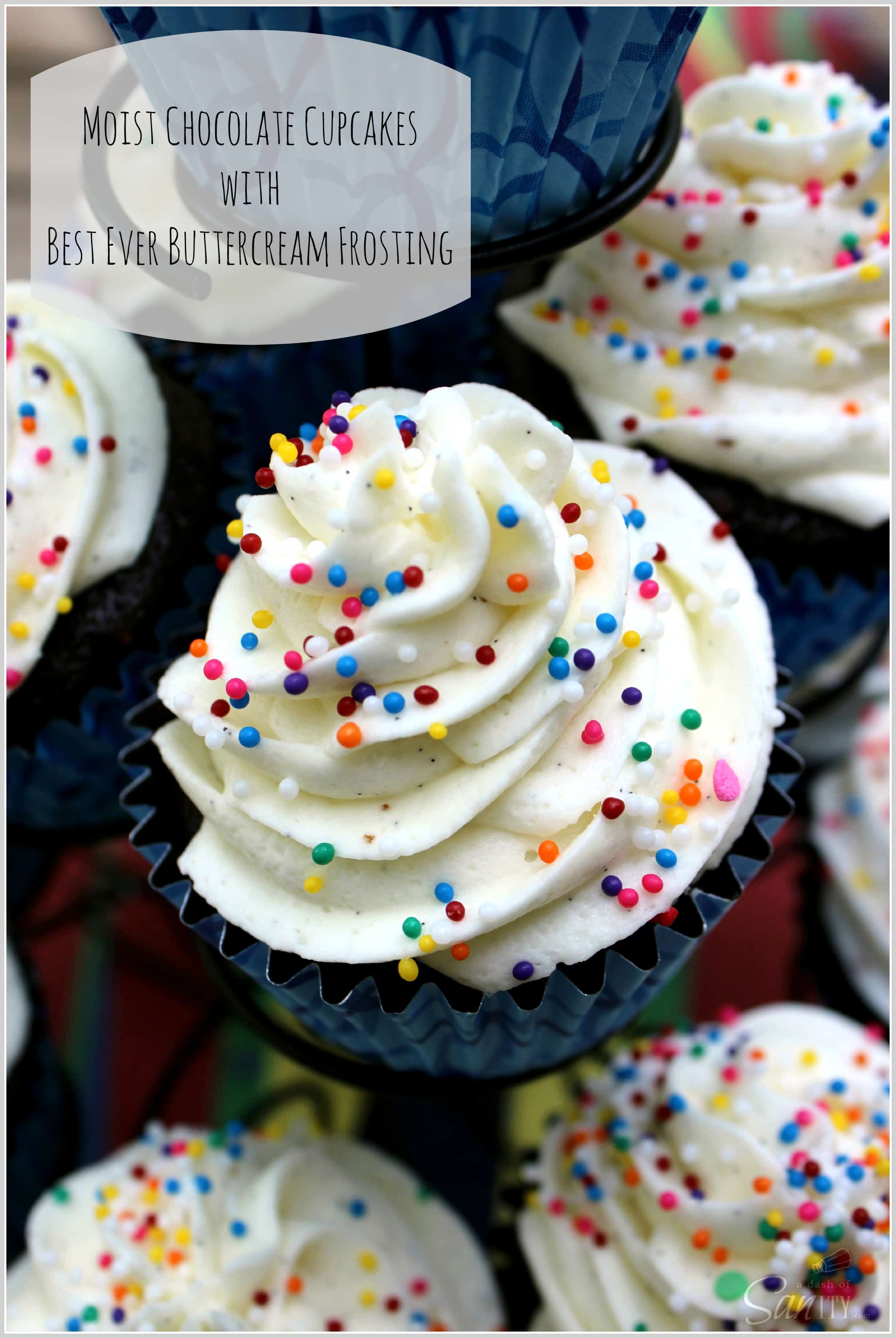 These classic Moist Chocolate Cupcakes with Best Ever Buttercream Icing are the perfect sweet treat for birthdays or just for fun. Moist Chocolate Cupcakes with Best Ever Buttercream Icing on a cupcake rack with rainbow sprinkles