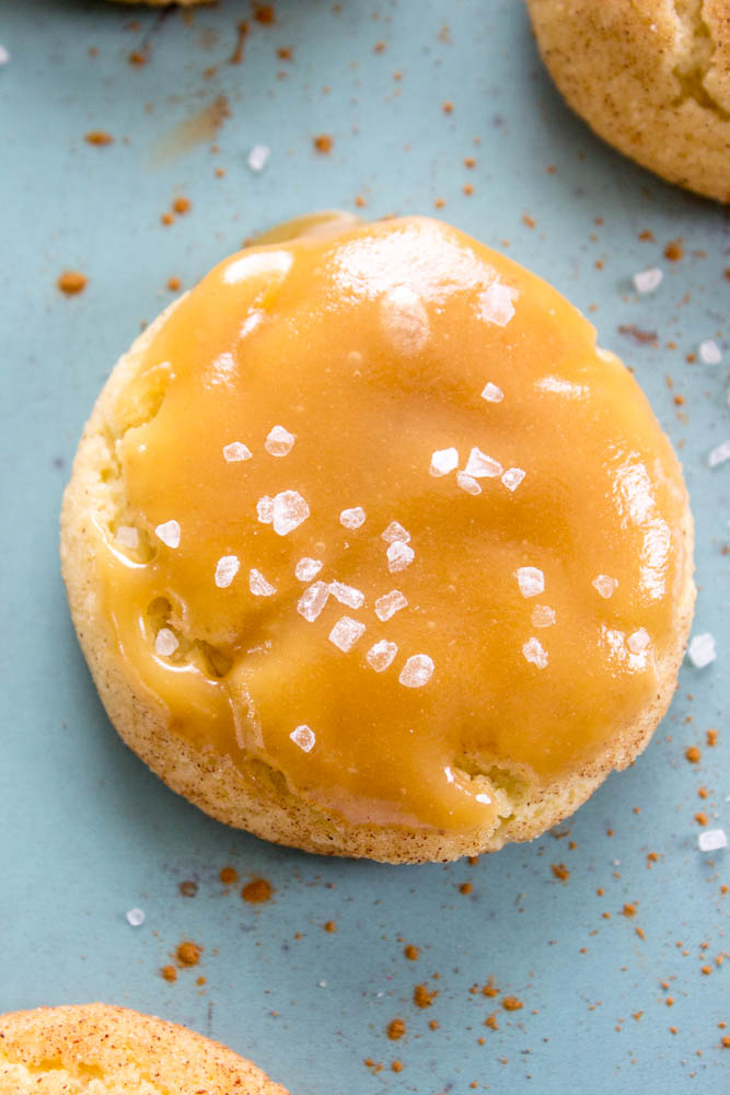 close up top down photo of a White Chocolate Caramel Snickerdoodle with caramel icing and flaked salt on top
