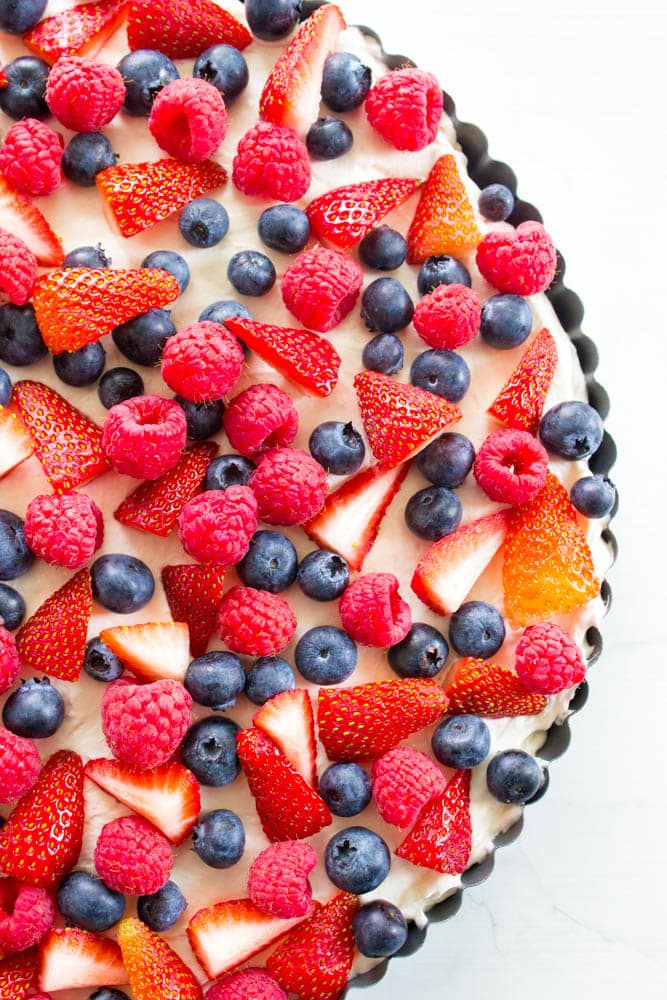 Insanely delicious & easy this Simple No-Bake Fruit Tart is made with an almond graham cracker crust, cream cheese filling, then topped with fresh fruit. top view of No Bake Fruit Tart