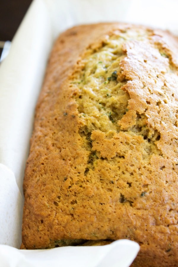 This BEST EVER ZUCCHINI BREAD recipe comes from my grandma, so naturally there isn't a better zucchini bread recipe out there. loaf of ZUCCHINI BREAD in bread pan lined with parchment paper