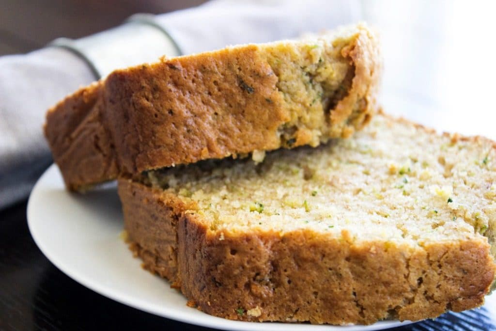 This BEST EVER ZUCCHINI BREAD recipe comes from my grandma, so naturally there isn't a better zucchini bread recipe out there. zucchini bread slices on a white plate