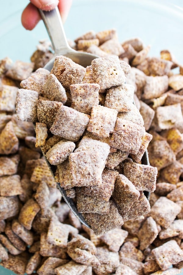 CHOCOLATE CHURRO MUDDY BUDDIES - a collision of your classic Muddy Buddies & churros making the best cinnamon & sugar bite sized treat. Chocolate churro muddy buddies in a metal scoop up close