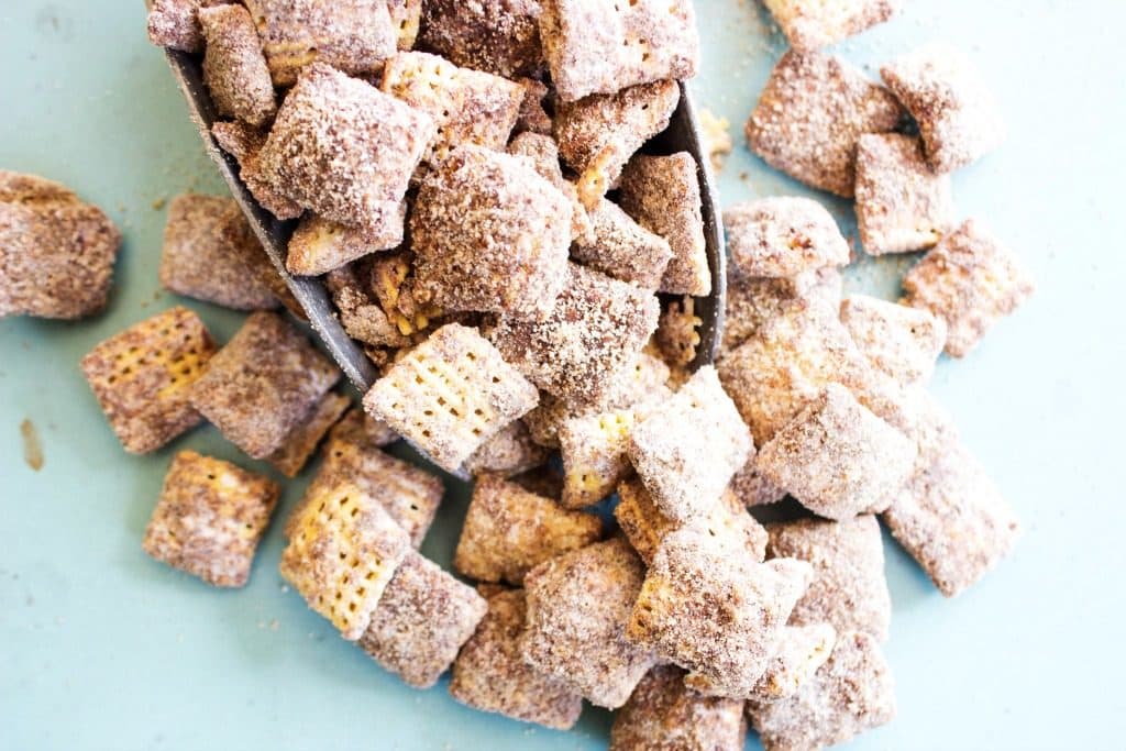 CHOCOLATE CHURRO MUDDY BUDDIES - a collision of your classic Muddy Buddies & churros making the best cinnamon & sugar bite sized treat. Up close chocolate churro muddy buddies in metal scoop