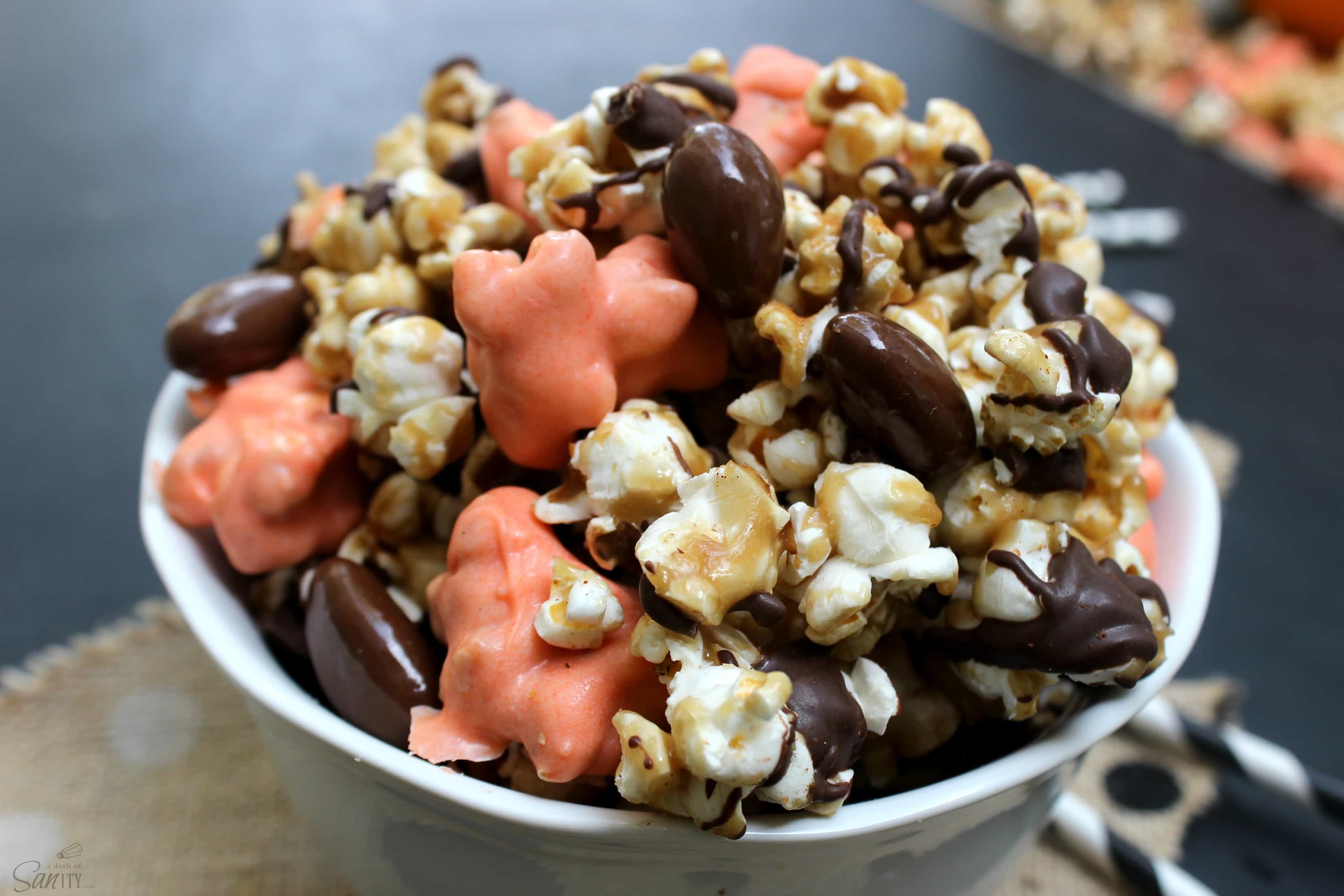 This Caramel Pumpkin Crunch is festive & delicious. Made with Amish Caramel Corn, chocolate covered almonds, dark chocolate, and cinnamon swirls.