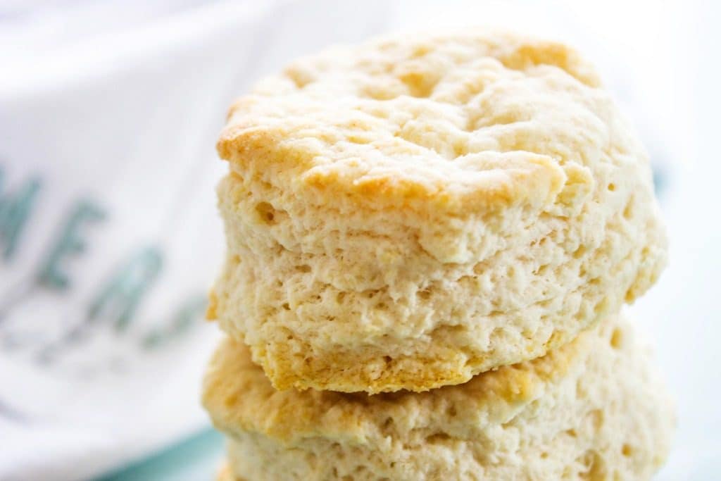 Ready minutes these COPYCAT KFC BISCUITS are light and flaky with layers of buttery dough, you will love these with jam, gravy or more butter. close up of a stack of Copycat KFC Biscuits