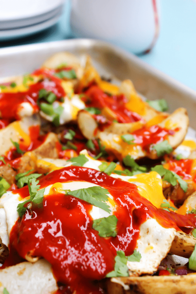 COLORADO BREAKFAST HASH flavorful, vibrant and easy, this super simple meal won’t be made just for breakfast but for lunch and dinner as well. breakfast hash on baking sheet with hash browns, eggs, sauce, cheese and peppers