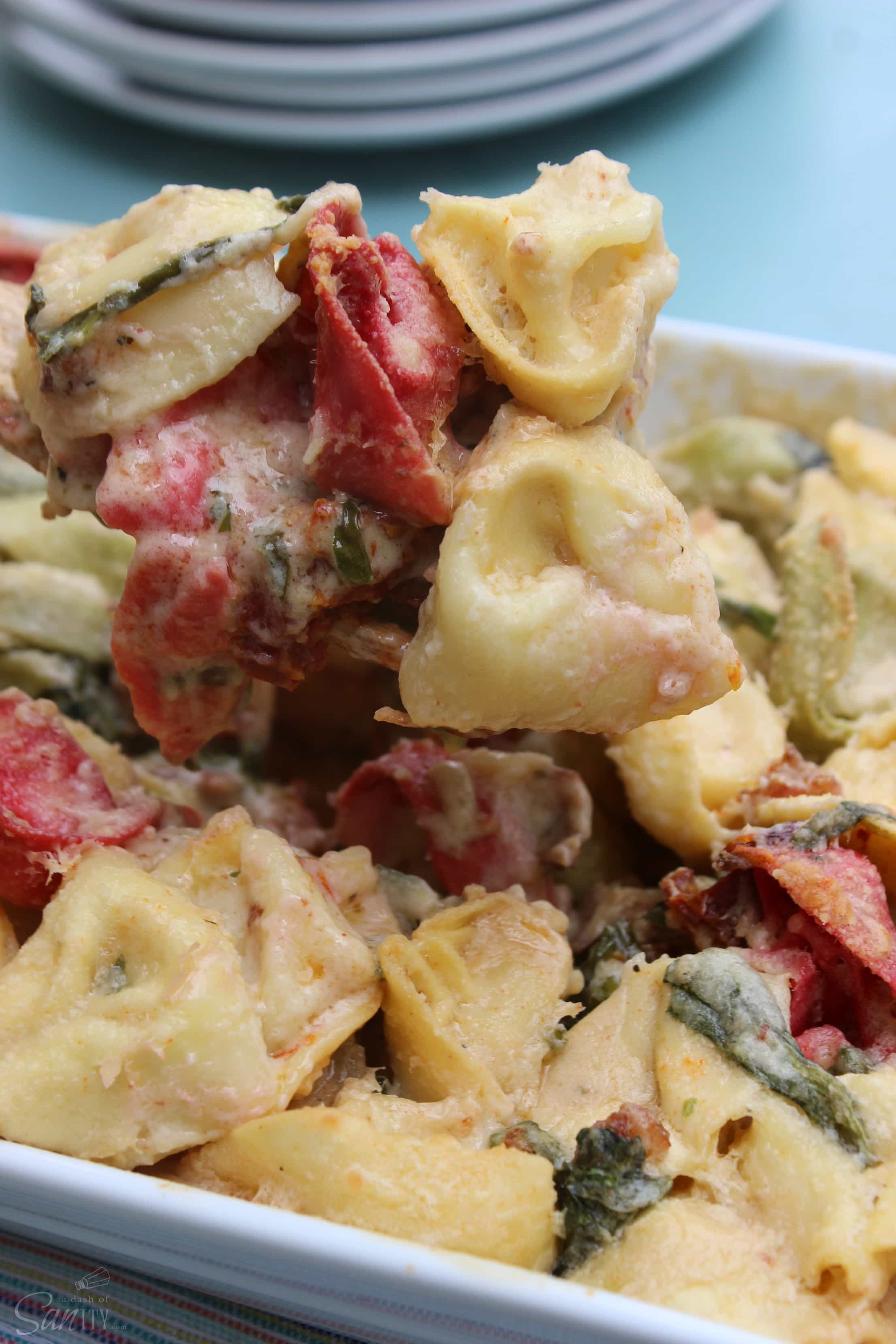 This easy to make Creamy Tortellini Bake is made with five-cheese tortellini, spinach, and light Alfredo sauce with a hint of bacon and sun-dried tomatoes.