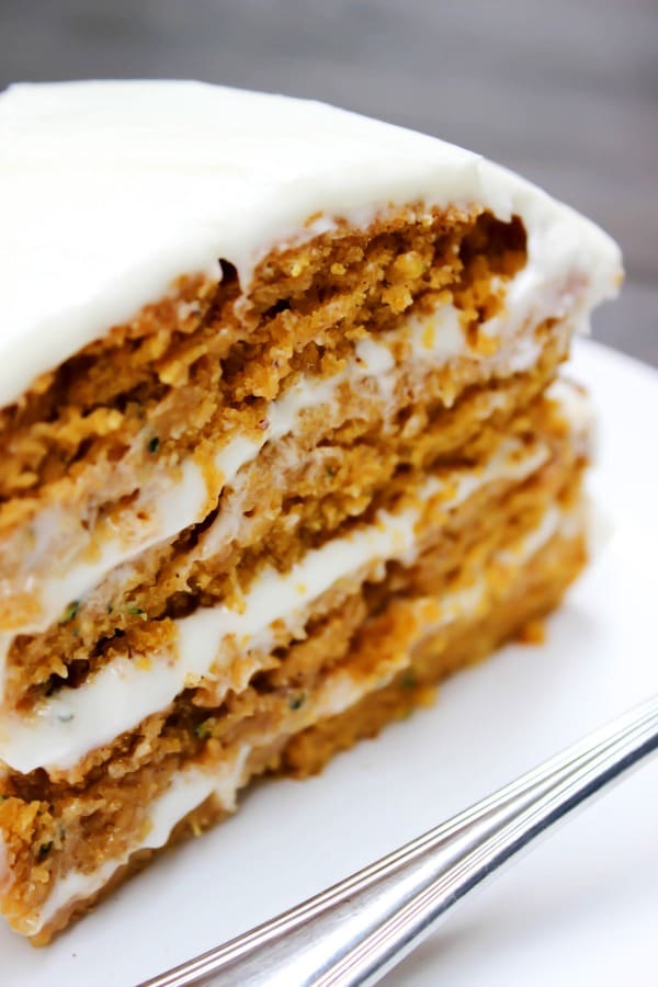 Absolutely dreamy this PUMPKIN ZUCCHINI CAKE is covered in cream cheese frosting, creating the perfect combination for the most delicious cake. close-up shot of the slice of cake.