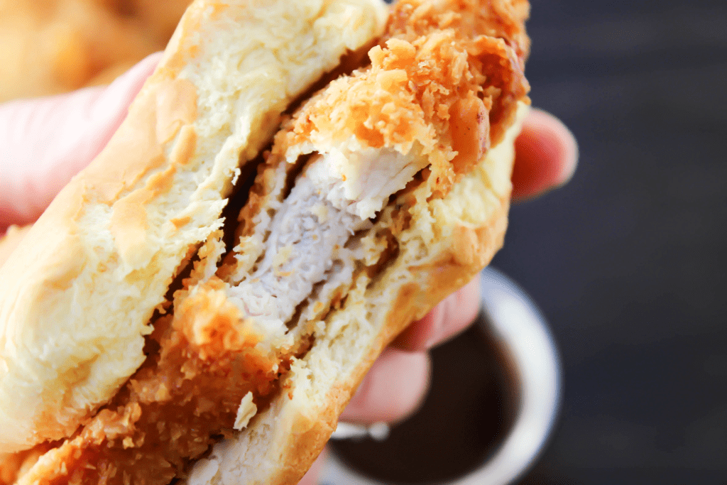 Crispy Pork Tenderloin Sandwiches deliciously crispy on the outside, tender and juicy in the center, these Iowa-inspired sandwiches will become a favorite. up close Pork Tenderloin Sandwich with bite taken