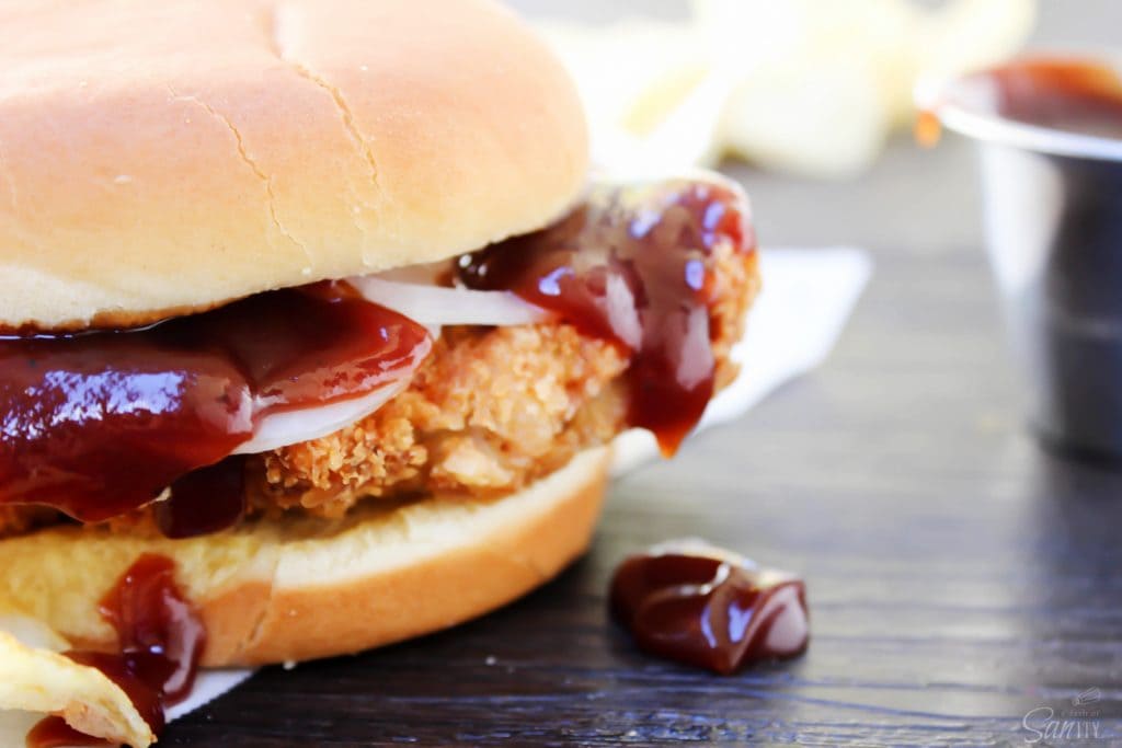 Crispy Pork Tenderloin Sandwiches deliciously crispy on the outside, tender and juicy in the center, these Iowa-inspired sandwiches will become a favorite. up close Pork Tenderloin Sandwich with barbecue on top of pork