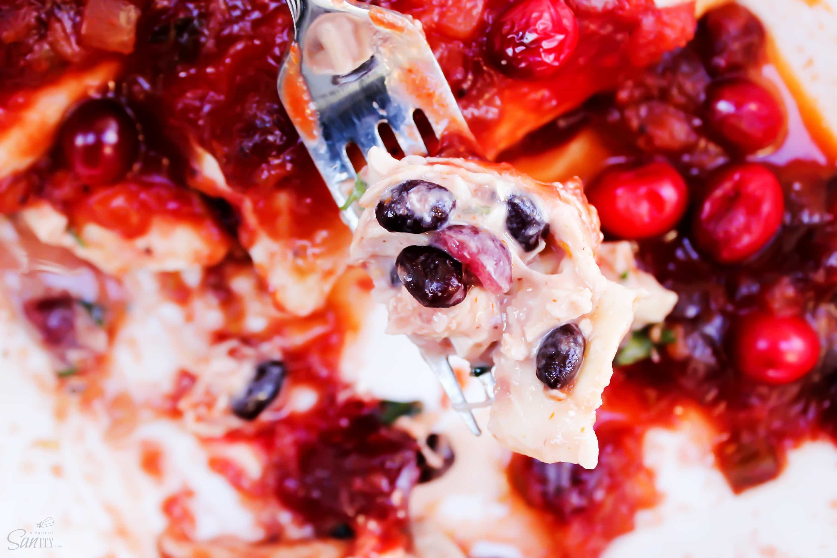 Made with a tangy-sweet sauce these Cran-Turkey Enchiladas are the best twist on enchiladas that I have ever had. Don't wait for the holidays to make these! fork of cranberry enchiladas