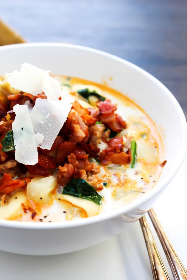 Tortellini Zuppa Toscana served in a bowl garnished with shaved parmesan