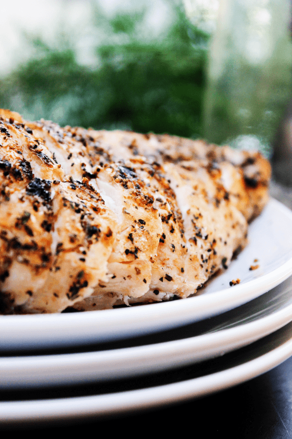 close up shot of grilled chicken with seasoning on plate