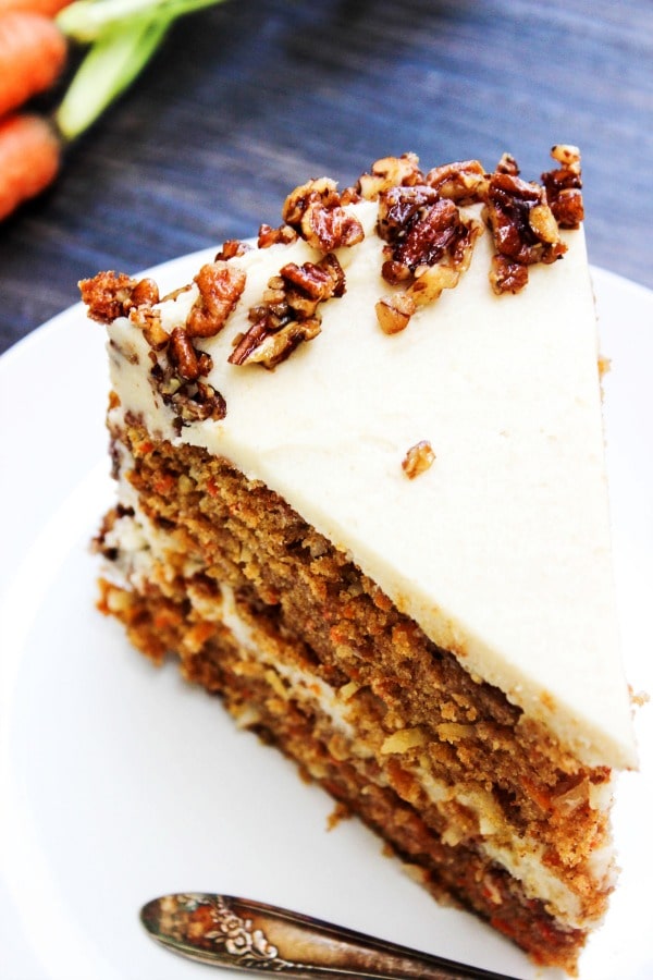 Carrot Cake with Maple Brown Sugar Buttercream & Candied Pecans with coconut, maple syrup, brown sugar, and pecans make a combo that will have you swooning. slice of carrot cake on a plate