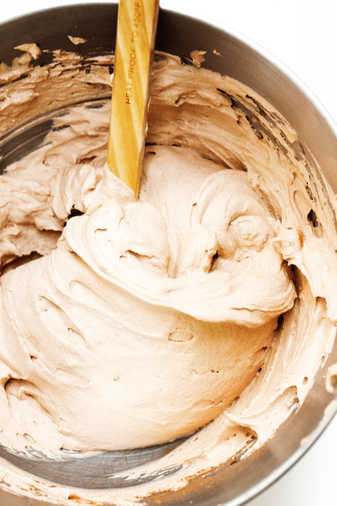 Chocolate Whipped Cream in a metal bowl with a wooden spoon