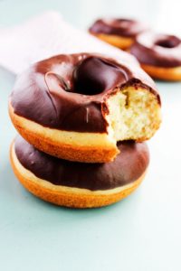 two cake donuts stacked one with a bite out of it