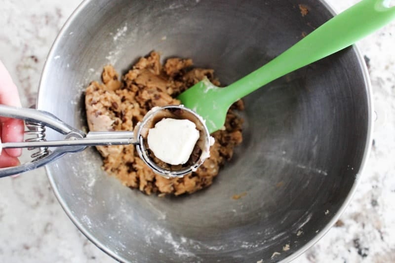 Insanely delicious and fun for summer these Chocolate Chip Cookie Dough Ice Cream Bites are bite-sized ice cream wrapped in chocolate chip cookie dough. Chocolate Chip Cookie Dough pressed in scoop with ball of ice cream in middle