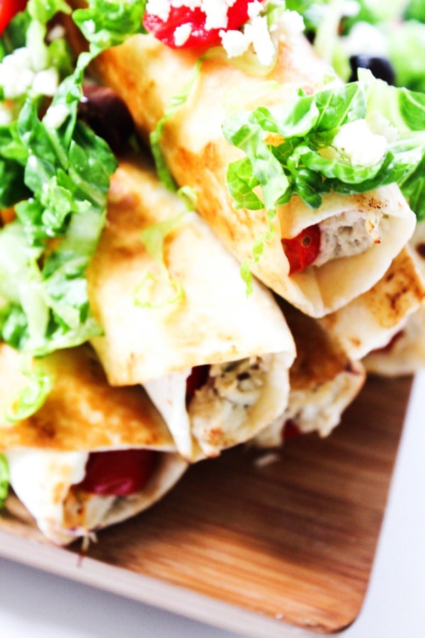 Slow Cooker Greek Chicken Taquitos is a twist on classic chicken taquitos. Made with fresh tomatoes, feta, and Greek dressing, this is so easy & delicious. 