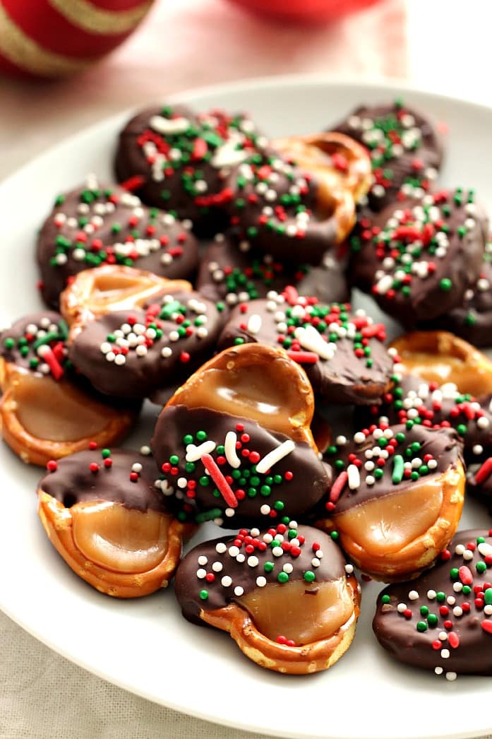 Easy Chocolate Caramel Bites - hard pretzels with caramel and chocolate dipped, red green white holiday sprinkles