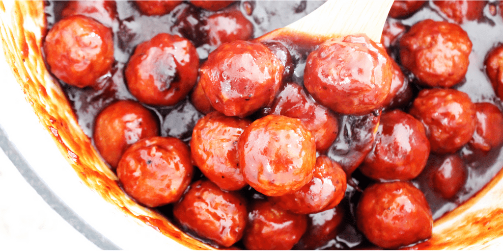 SWEET & TANGY BARBECUE MEATBALLS - Ready in 30-minutes and made with a few simple ingredients, they make appetizer or even as dinner a meatball subs. up close Sweet & Tangy Barbecue Meatballs in large pot with a wooden spoon