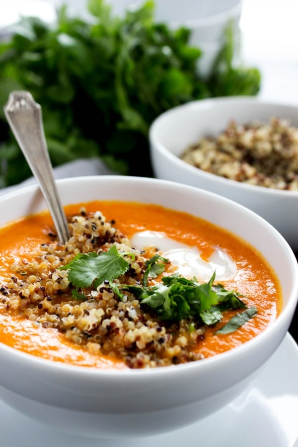 Thai Curry Red Pepper Quinoa Soup is an easy 30-minute meal made with red curry, coconut milk and quinoa. Skip take-out and make this healthy twist instead. photo of Thai Curry Red Pepper Quinoa Soup in a white bowl, with cilantro and a bowl of quinoa in background