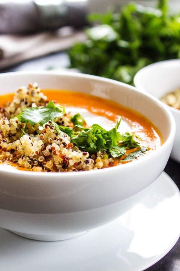 Thai Curry Red Pepper Quinoa Soup is an easy 30-minute meal made with red curry, coconut milk and quinoa. Skip take-out and make this healthy twist instead. side view photo of Thai Curry Red Pepper Quinoa Soup in a white bowl, with garnish