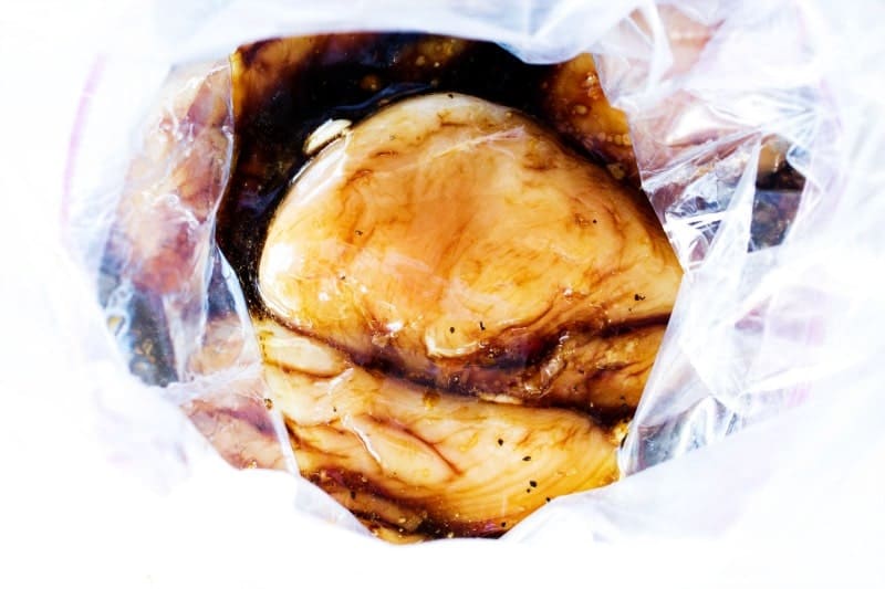 These Sweet Ginger Teriyaki Chicken Bowls made in just 30 minutes, are a healthy, filling, yet delicious dinner that will have you skipping take-out. photo of raw chicken breasts marinating in sauce in a ziploc bag