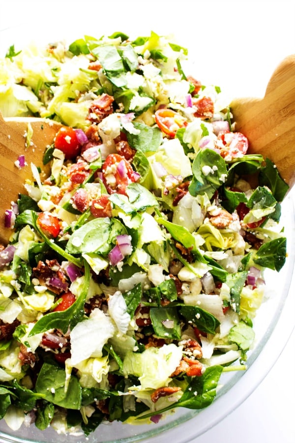 Chopped Wedge Salad is a simple green salad, fully loaded with bacon & blue cheese. Dress it up or down, either way the entire family will love this salad. photo of chopped wedge salad in a glass serving bowl