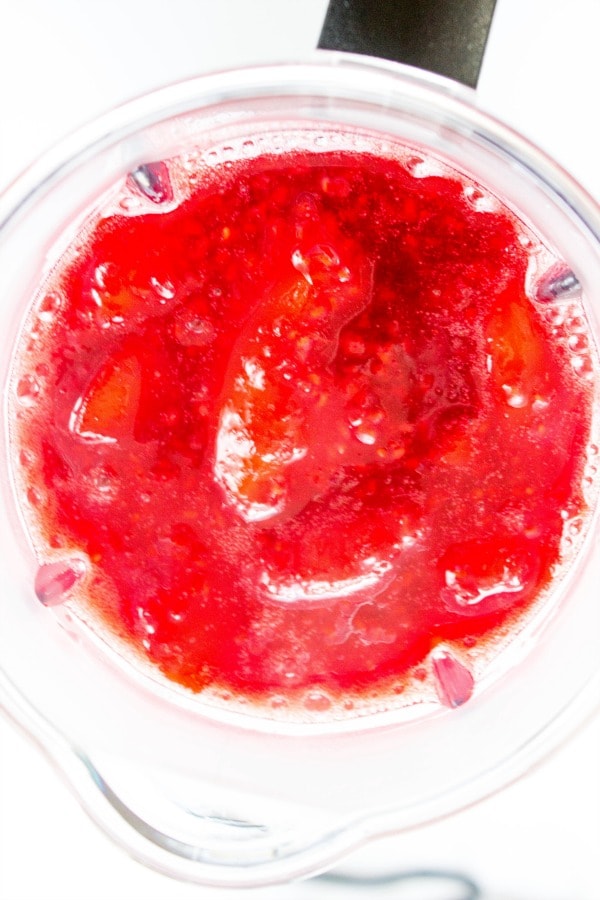 RASPBERRY PEACH SAUCE - a classic summer combination of peaches and raspberries made into a gorgeous sauce that will brighten any dish. From dessert to breakfast you will want to pour this sauce on it all. overhead shot of blender with sauce