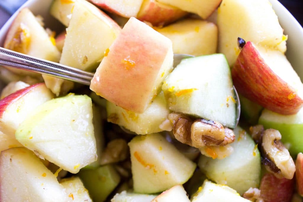 APPLE WALNUT SALAD - Metal spoon, white bowl