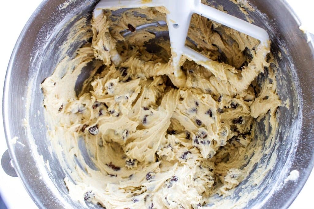 overhead shot of chocolate chips over bowl of cookie dough