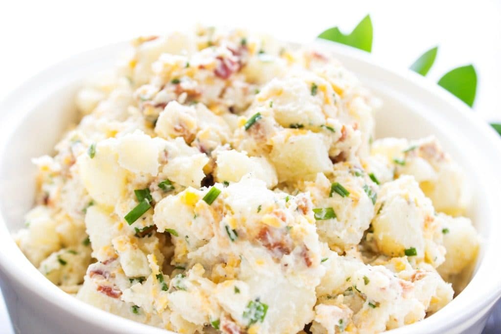 BEST EVER POTATO SALAD RECIPE - loaded with bacon, chives, cheese and ranch seasoning, this potato salad will become a traditional family barbecue recipe. close up shot of potato salad in bowl