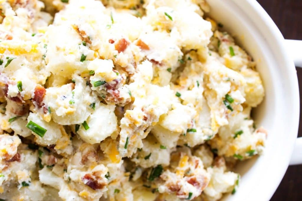 BEST EVER POTATO SALAD RECIPE - loaded with bacon, chives, cheese and ranch seasoning, this potato salad will become a traditional family barbecue recipe. BEST EVER POTATO SALAD RECIPE, bacon, chives, cheddar cheese in white bowl