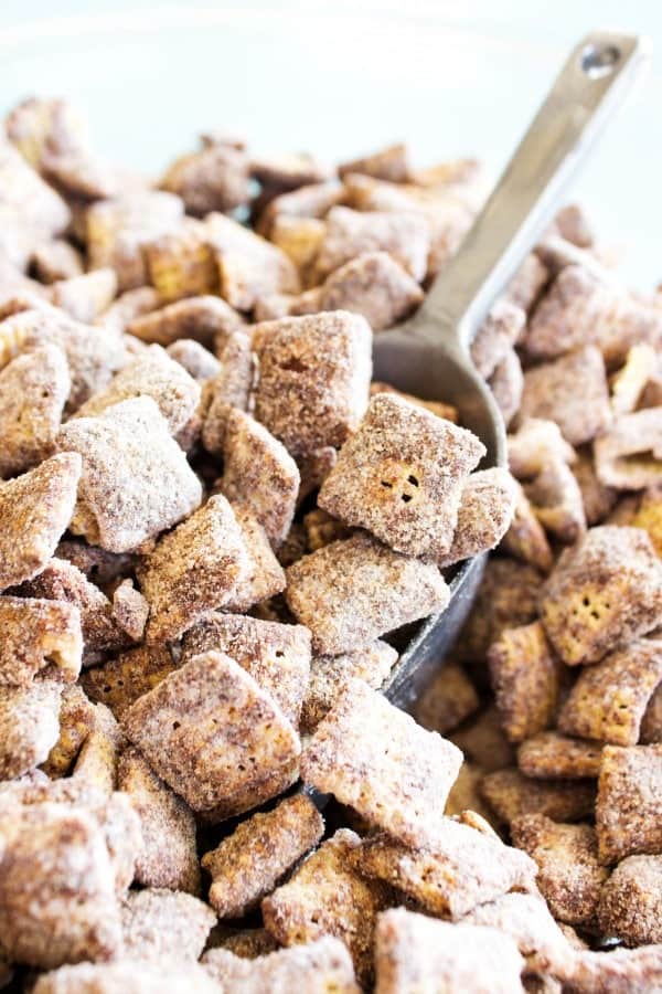 CHOCOLATE CHURRO MUDDY BUDDIES - a collision of your classic Muddy Buddies & churros making the best cinnamon & sugar bite sized treat. pile of chocolate churro muddy buddies with metal scoop