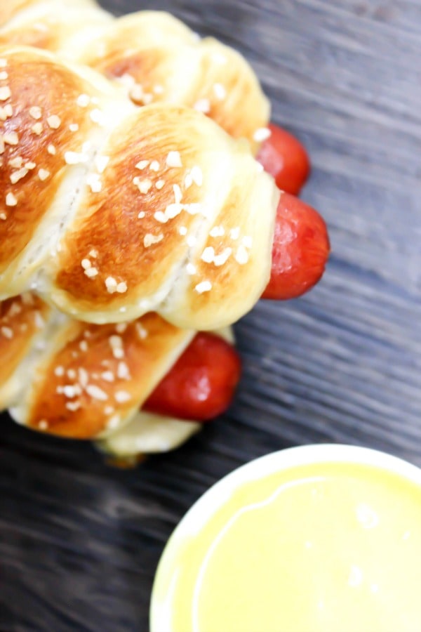 Simple & delicious these EASY PRETZEL HOT DOGS are the perfect combination a hot dog and a soft pretzel- a kid favorite in our home. overhead shot mustard and pretzel hot dogs