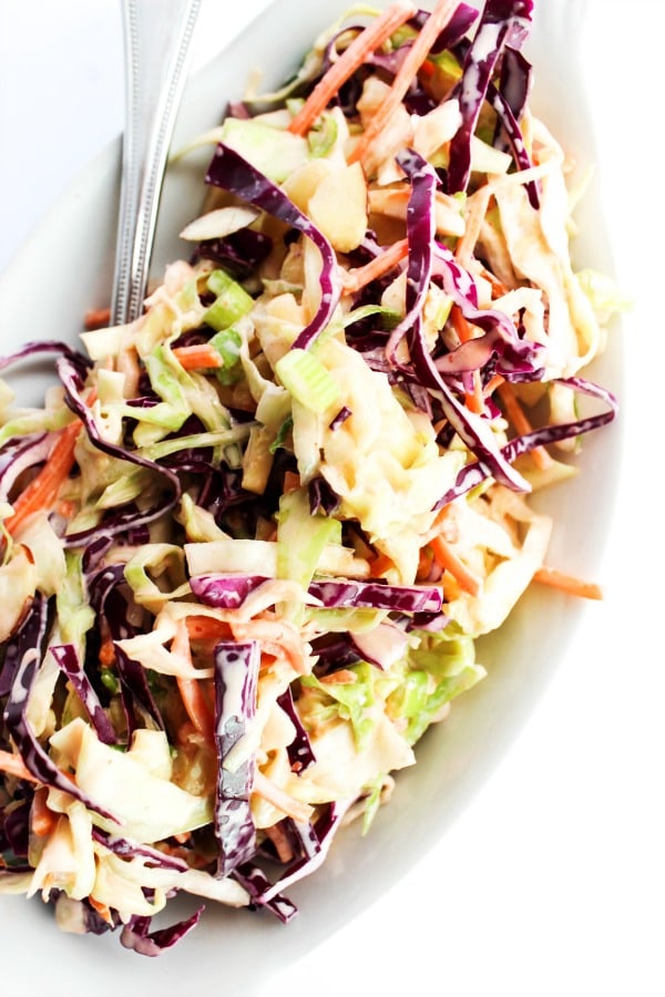HONEY SRIRACHA COLESLAW a delicious twist on your classic coleslaw. Dress up a sandwich or serve on the side either way this will be a real crowd pleaser. overhead shot of coleslaw