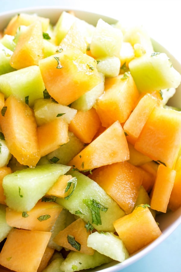 close up of honey dew and cantalope in a bowl with mint