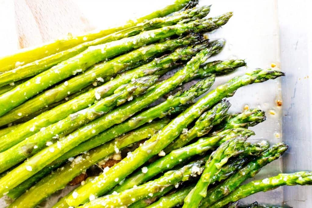 EASY OVEN ROASTED GARLIC ASPARAGUS - a simple & delicious way to prepare & cook asparagus in just under 20 minutes. EASY OVEN ROASTED GARLIC ASPARAGUS - Asparagus on metal pan