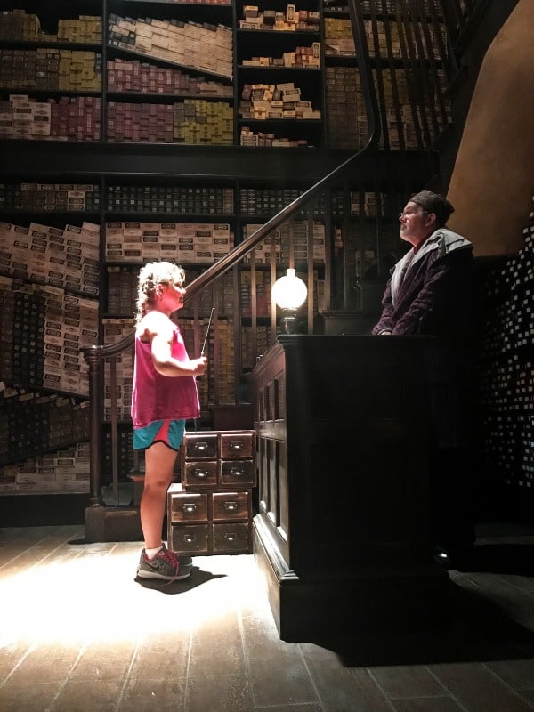 photo of girl holding a wand at ollivanders wand shop